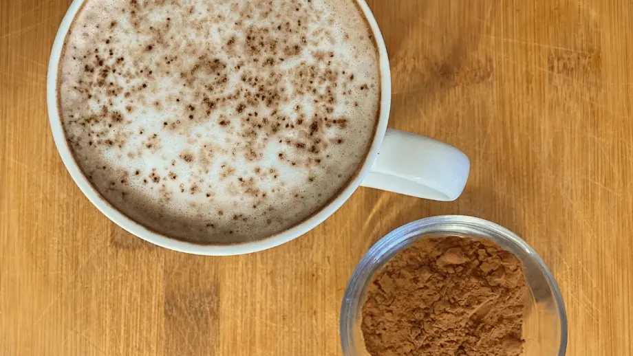 Cocoa coffee and cocoa powder on a wooden surface.