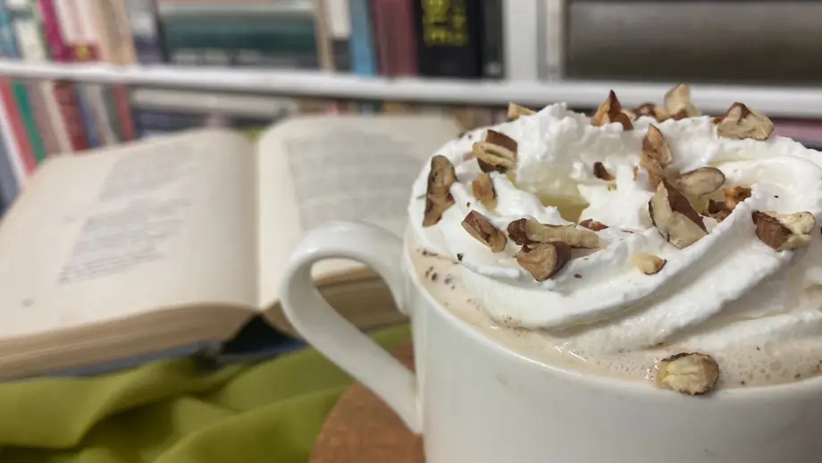 Maple pecan latte in a white mug in front of a book.