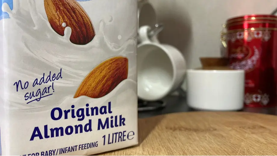 Almond milk in a box on a wooden surface.