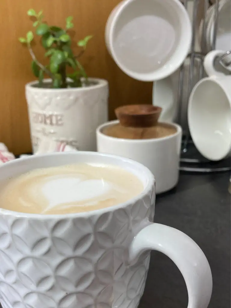 Honey latte in a textured white mug.