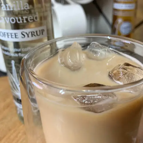 Vanilla iced coffee in double walled glass.
