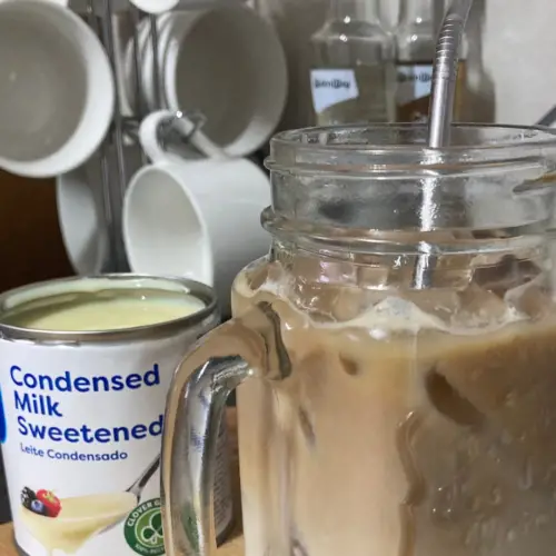 Condensed milk iced coffee and condensed milk on wooden surface